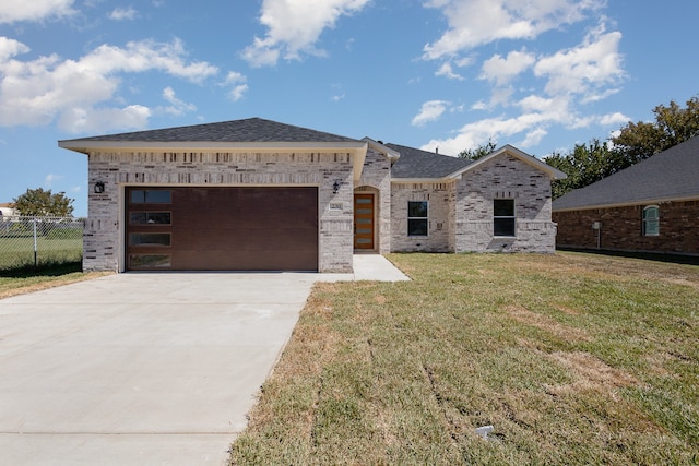 view of front of home with a front yard and a garage