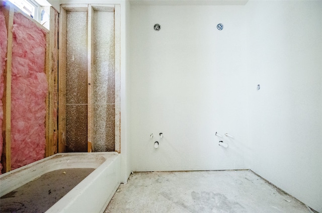 bathroom featuring a washtub and concrete floors