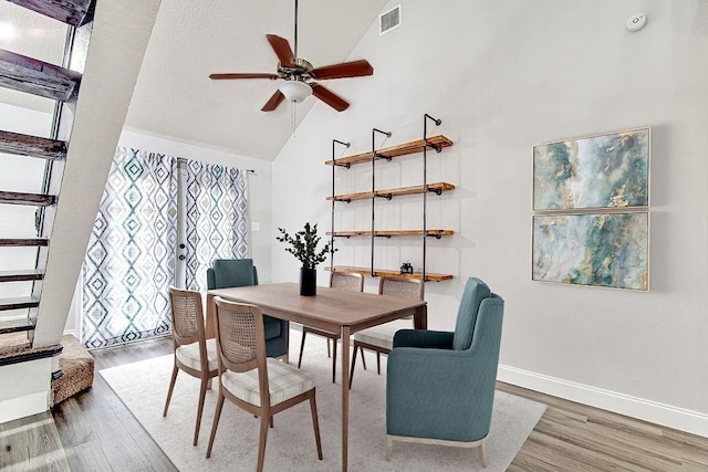 dining space featuring ceiling fan, hardwood / wood-style floors, and high vaulted ceiling