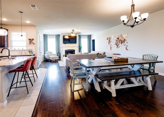 dining space featuring sink, hardwood / wood-style flooring, and ceiling fan with notable chandelier