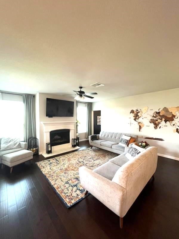 living room featuring ceiling fan and dark hardwood / wood-style flooring