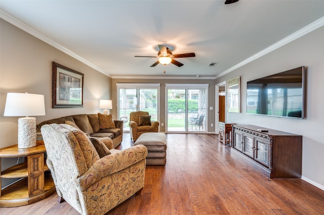 living room featuring ceiling fan, ornamental molding, and hardwood / wood-style floors