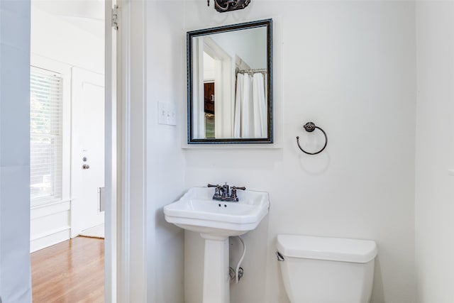 bathroom with hardwood / wood-style floors, toilet, and a healthy amount of sunlight