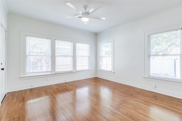 spare room with ceiling fan, a healthy amount of sunlight, wood-type flooring, and crown molding