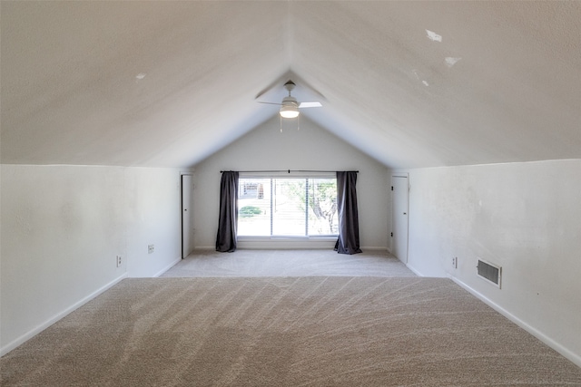 additional living space featuring light carpet, ceiling fan, and lofted ceiling