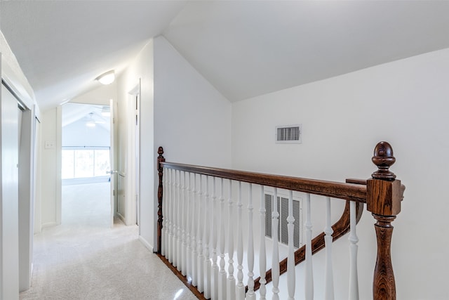 corridor with light colored carpet and lofted ceiling