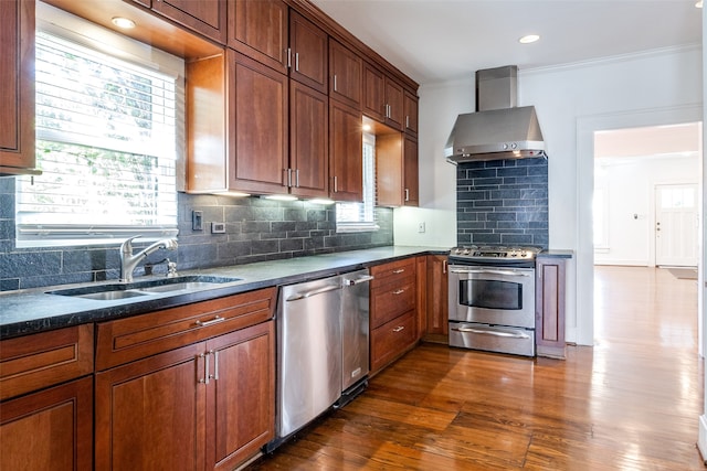 kitchen featuring sink, wall chimney exhaust hood, dark hardwood / wood-style flooring, backsplash, and appliances with stainless steel finishes