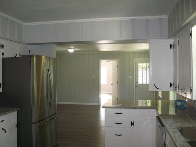 kitchen with light stone counters, dark wood-type flooring, white cabinetry, stainless steel appliances, and crown molding