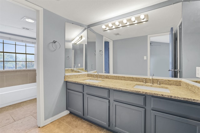 bathroom featuring tile patterned flooring, vanity, a tub to relax in, and ceiling fan