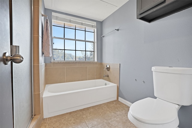 bathroom with tile patterned floors, toilet, and a tub