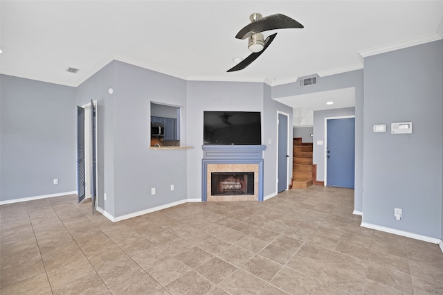 unfurnished living room featuring a tile fireplace, ceiling fan, and crown molding