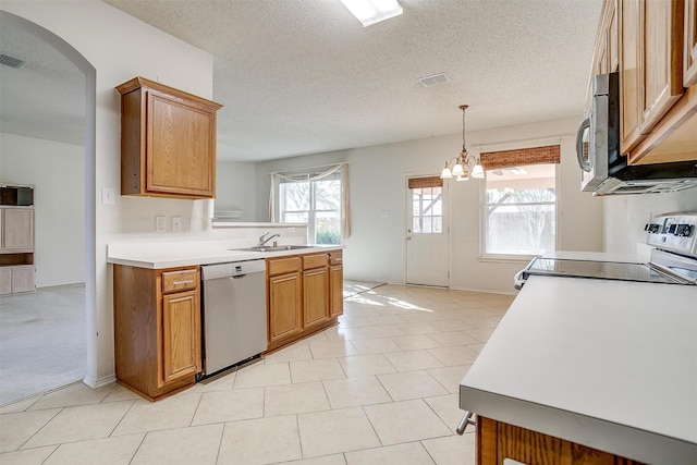 kitchen featuring appliances with stainless steel finishes, a textured ceiling, pendant lighting, and a chandelier