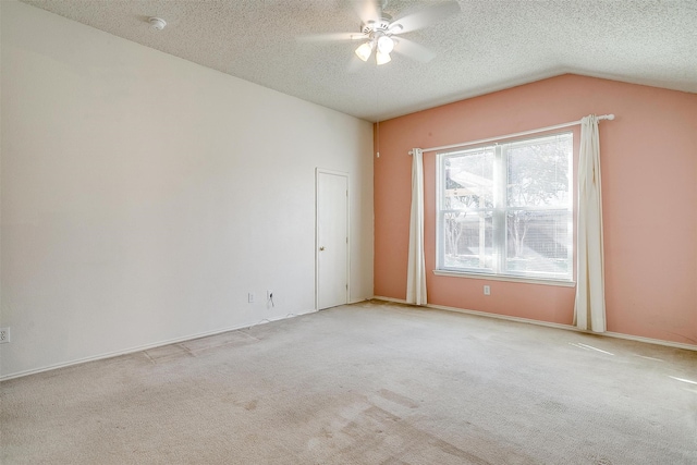 carpeted spare room with vaulted ceiling, ceiling fan, and a textured ceiling