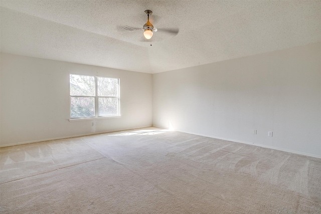 unfurnished room featuring light carpet, ceiling fan, and a textured ceiling