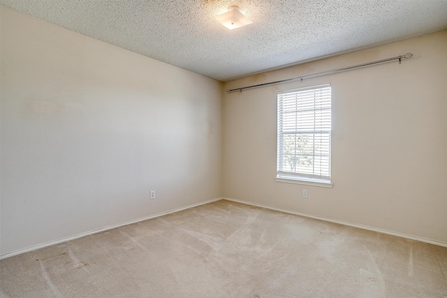 carpeted empty room featuring a textured ceiling