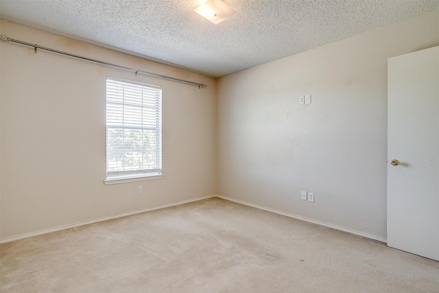 carpeted empty room featuring a textured ceiling