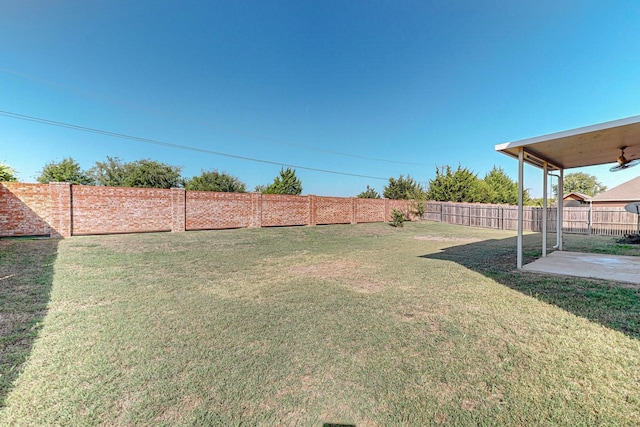 view of yard with ceiling fan and a patio area