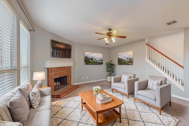 carpeted living room featuring ceiling fan and a brick fireplace