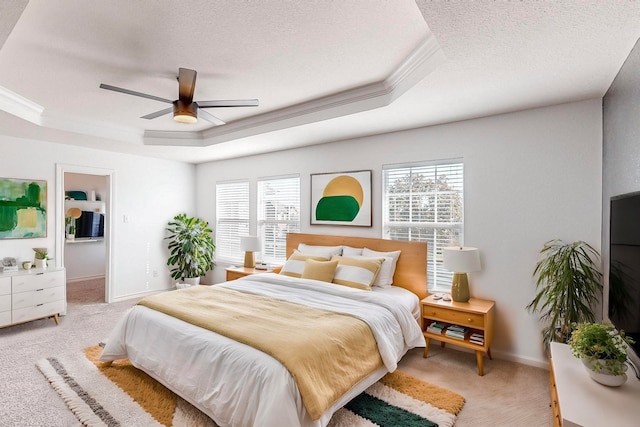 carpeted bedroom with multiple windows, a raised ceiling, and ceiling fan