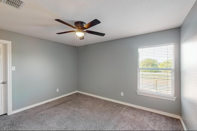 carpeted spare room featuring ceiling fan and a textured ceiling