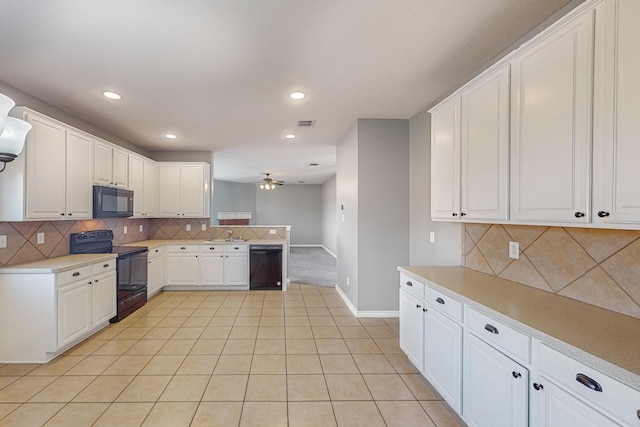 kitchen featuring light tile patterned floors, sink, backsplash, white cabinetry, and black appliances