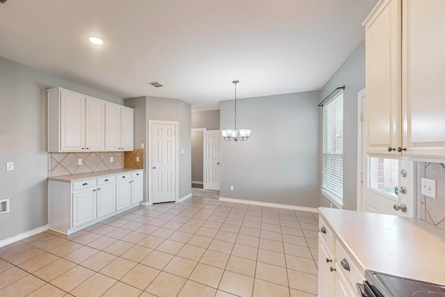 kitchen featuring light tile patterned flooring, decorative light fixtures, backsplash, white cabinetry, and a notable chandelier