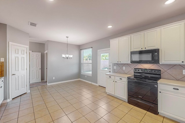 kitchen featuring black appliances, an inviting chandelier, light tile patterned floors, and white cabinets