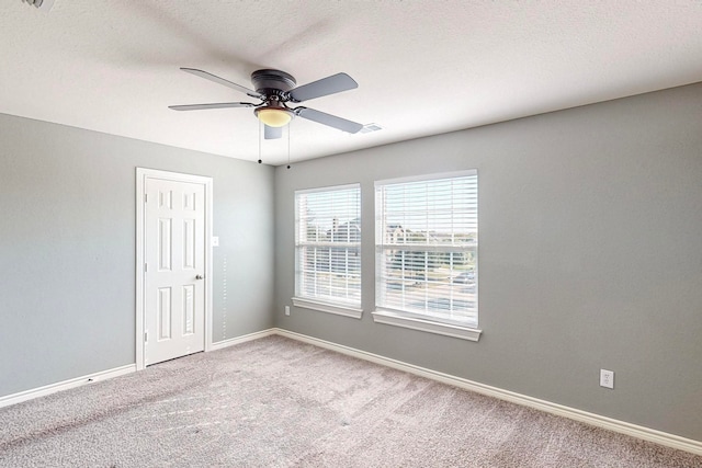 carpeted empty room with a textured ceiling and ceiling fan