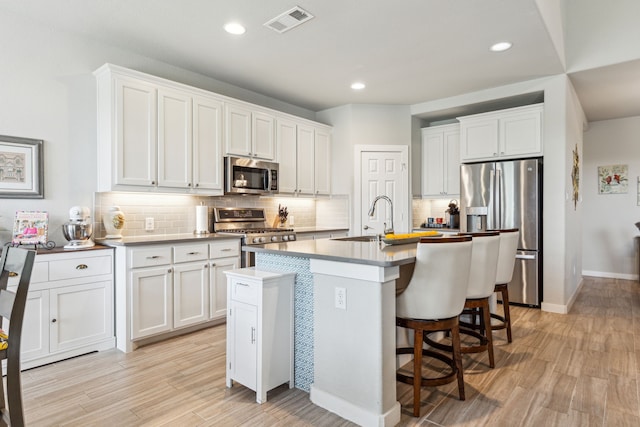 kitchen featuring decorative light fixtures, sink, white cabinetry, and stainless steel appliances