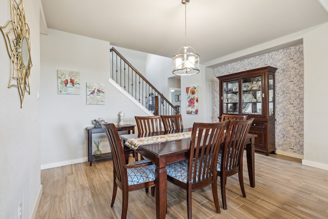 living room featuring high vaulted ceiling, ceiling fan, a stone fireplace, and light wood-type flooring