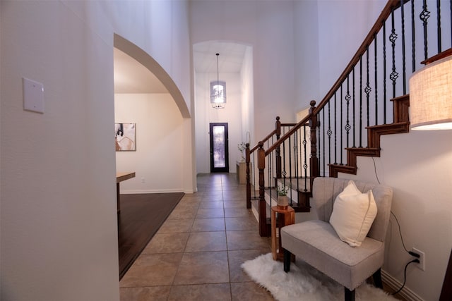 foyer with wood-type flooring and a towering ceiling