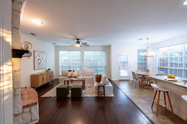 living room featuring ceiling fan with notable chandelier, dark hardwood / wood-style floors, and a wealth of natural light