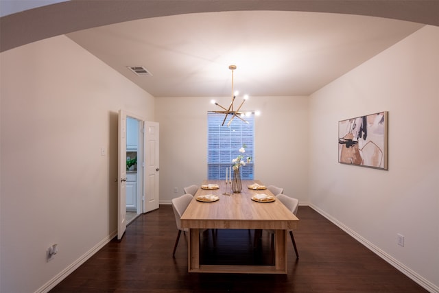 unfurnished dining area featuring a notable chandelier and dark wood-type flooring