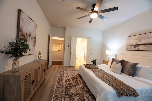 bedroom featuring light wood-type flooring, ceiling fan, and connected bathroom