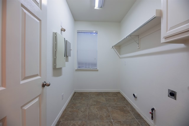 washroom featuring dark tile patterned flooring, hookup for an electric dryer, and hookup for a gas dryer