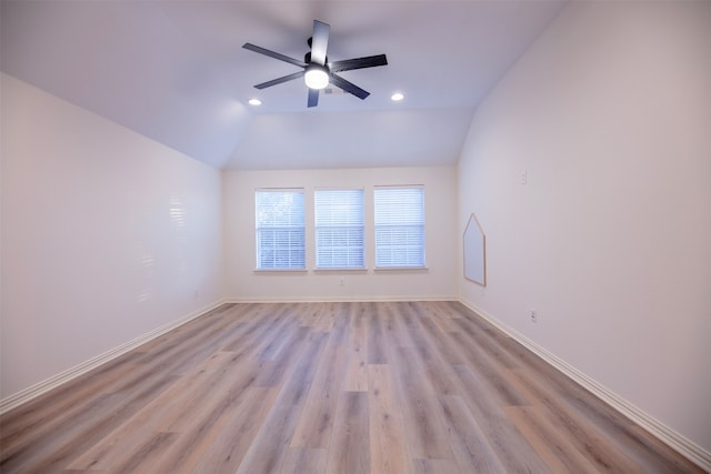 empty room with lofted ceiling, ceiling fan, and light hardwood / wood-style flooring