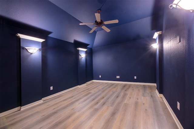 cinema room with ceiling fan, vaulted ceiling, and light hardwood / wood-style floors