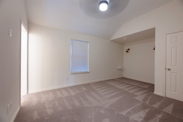 empty room featuring lofted ceiling, ceiling fan, and carpet floors