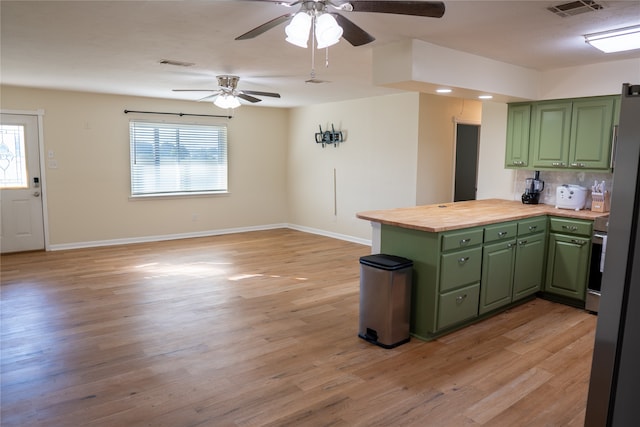 kitchen featuring wooden counters, green cabinets, and plenty of natural light