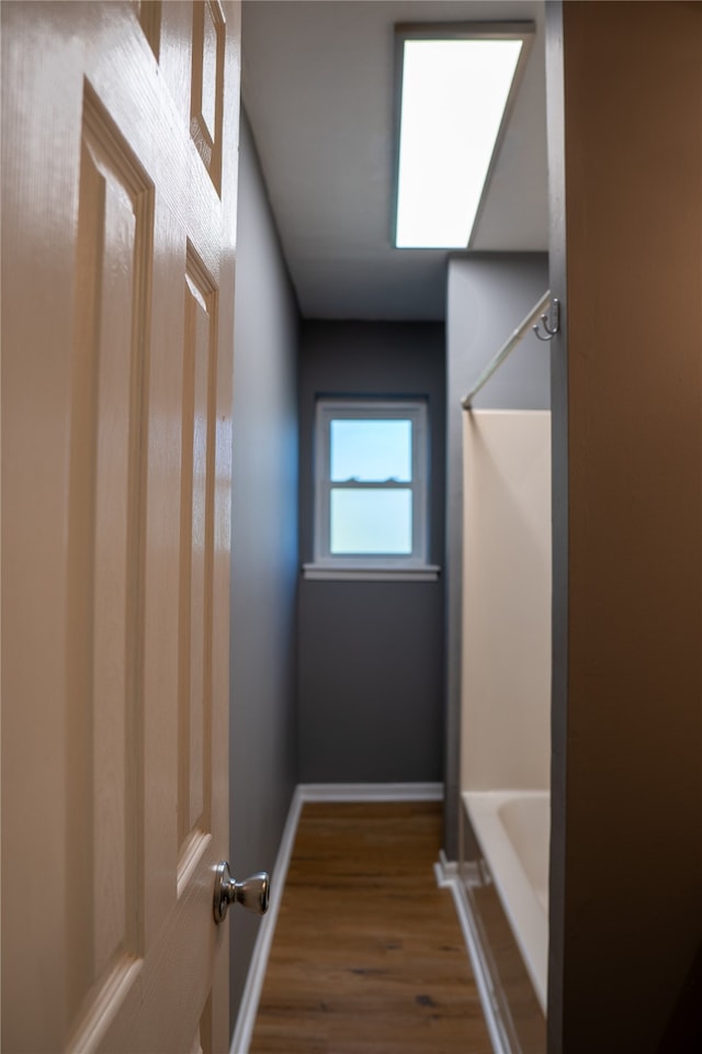 interior space with wood-type flooring and separate shower and tub