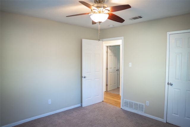 unfurnished bedroom with ceiling fan and light carpet