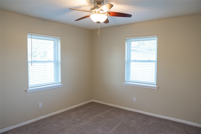 carpeted spare room featuring ceiling fan