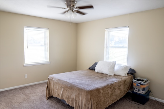 carpeted bedroom featuring multiple windows and ceiling fan