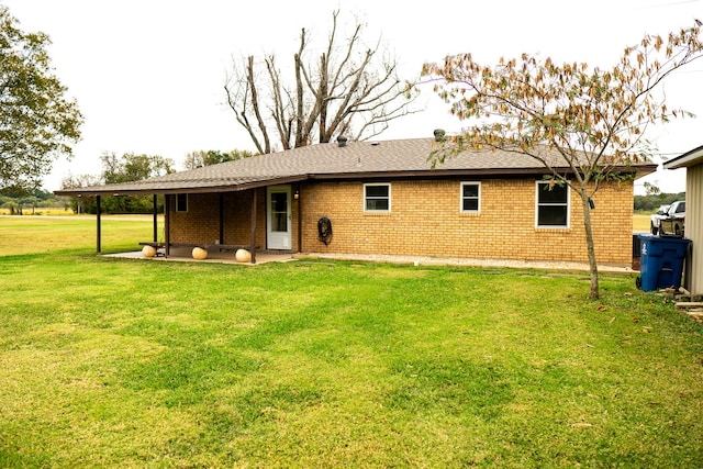 rear view of house featuring a patio and a yard