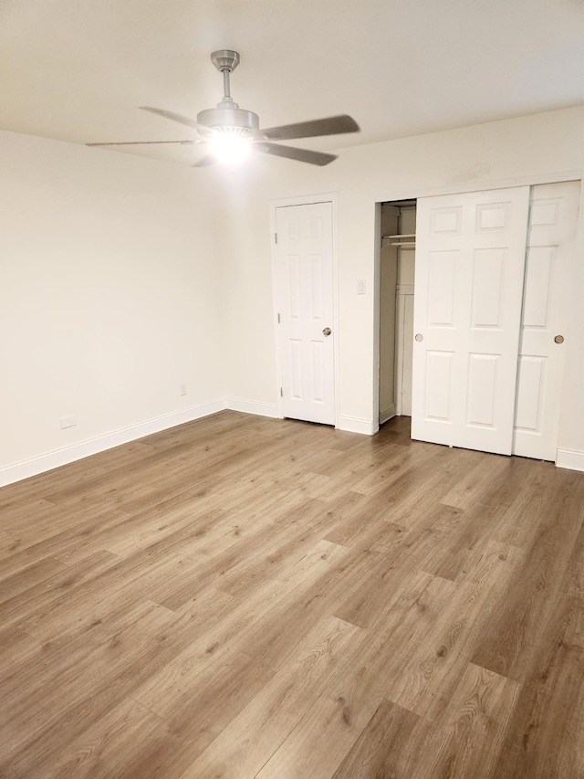 unfurnished bedroom with two closets, light hardwood / wood-style flooring, and ceiling fan