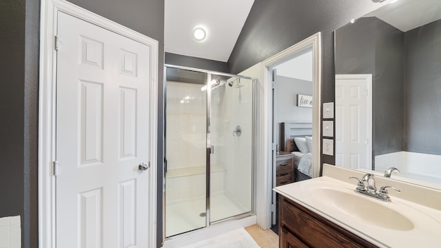 bathroom with tile patterned flooring, lofted ceiling, a shower with door, and vanity