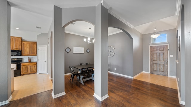 foyer featuring ornamental molding, hardwood / wood-style floors, and a notable chandelier