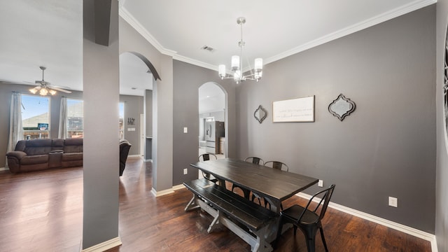 dining area with ceiling fan with notable chandelier, ornamental molding, and dark hardwood / wood-style flooring