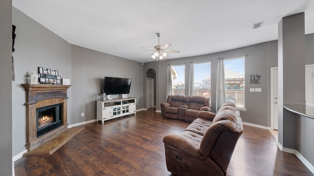 living room featuring ceiling fan and dark wood-type flooring