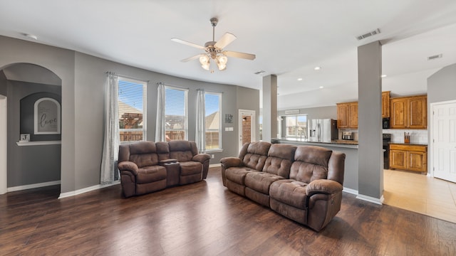 living room with dark hardwood / wood-style floors, ceiling fan, and plenty of natural light